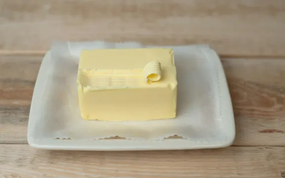 Nông dân "tăng tốc tối đa" để tận dụng giá sữa cao kỷ lục - Chuyên gia phân tích 2 A block of butter on a white dish.
