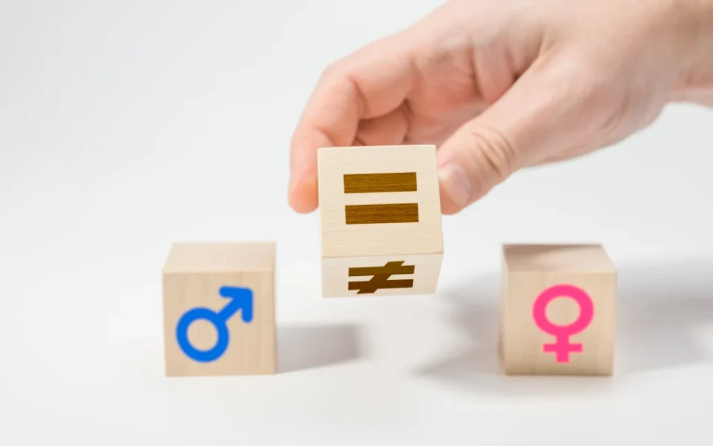 gender equality concept on wooden cubes. Concepts of gender equality. Hand flip wooden cube with symbol unequal change to equal sign. white background