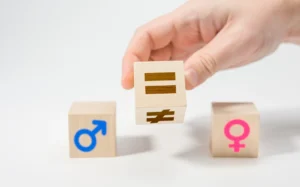 gender equality concept on wooden cubes. Concepts of gender equality. Hand flip wooden cube with symbol unequal change to equal sign. white background