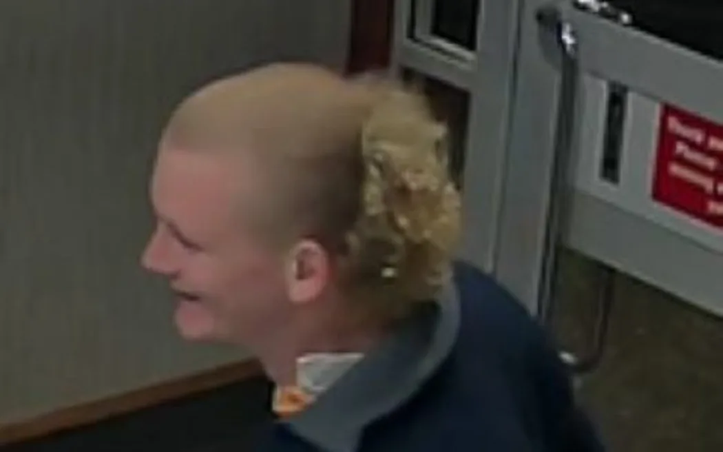 A man with blonde hair, light skin tone, wearing a navy blue jacket.