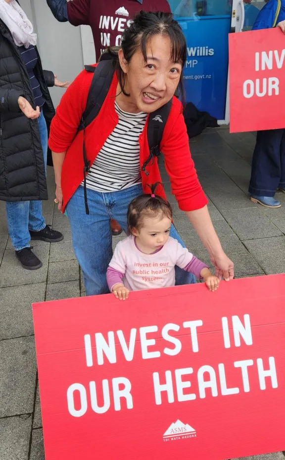 Wellington Regional Hospital gastroenterologist Amanda Chen - pictured here with two-year-old daughter Roisin picketing outside Finance Minister Nicola Willis' office - says doctors would rather be treating their patients than going on strike.