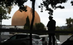 An armed policeman stands guard in front of the Masjid Al Noor Mosque in Christchurch on March 16, 2019. (Photo by MICHAEL BRADLEY / AFP)