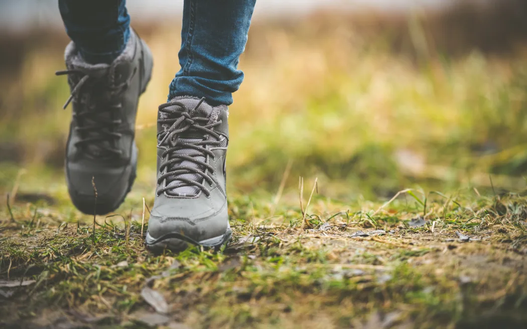 feet in shoes walking on a forest path