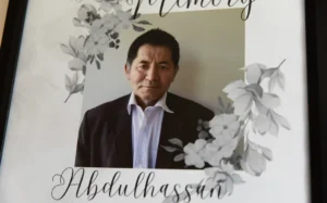 John Nabizadah with a picture of his father