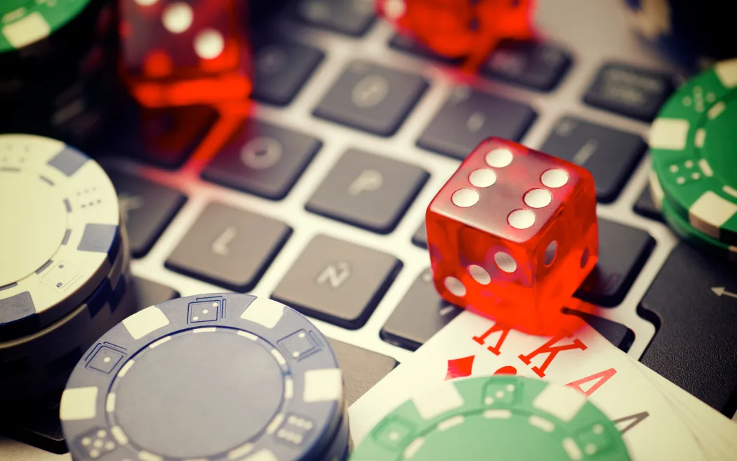 Casino chips, cards and dices stacking on a laptop