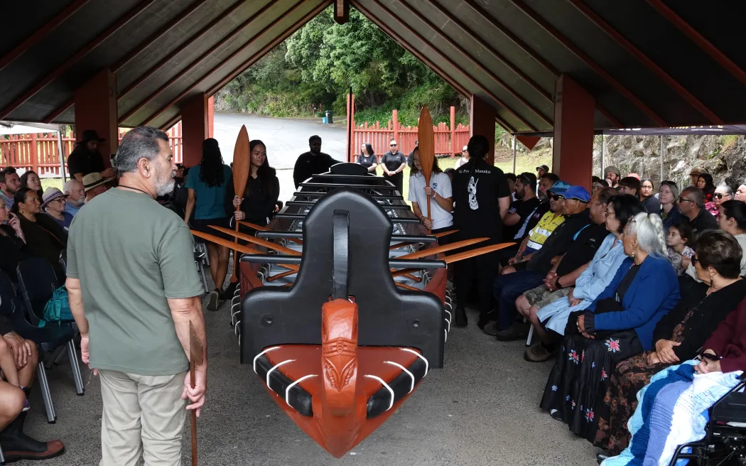 Freshly carved hoe [paddles] are placed in the waka as Ngāti Rēhia leader Kipa Munro conducts a blessing.