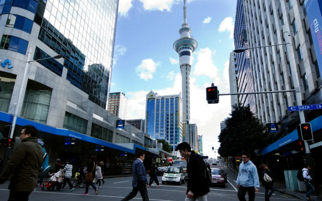 Bất động sản thương mại New Zealand: Khởi sắc mạnh mẽ trong môi trường đầu tư ổn định 1 AUCKLAND, NZ - MAY 29:Traffic on Queen street with the Skytower in the background on May 29 2013.It's a major commercial thoroughfare in the Auckland CBD, New Zealand's main population center.