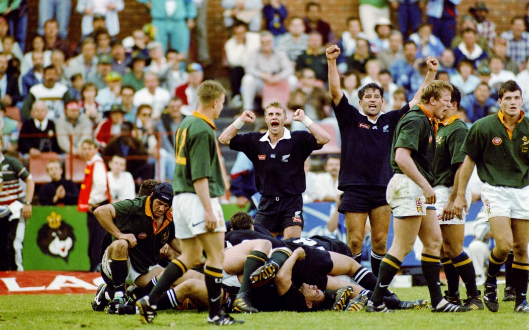 Đại kình địch tái ngộ: All Blacks xác nhận du đấu Nam Phi năm 2026 3 Justin Marshall (L) and Zinzan Brooke celebrate the series win in South Africa at Loftus Versfeld, Pretoria, 1996.