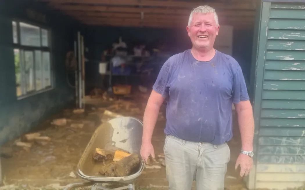 Sông Awakino vỡ bờ, nước cuồn cuộn dâng qua ván sàn, nhấn chìm nhiều ngôi nhà 3 Martin Hegason cleans up his flooded garage. His fence line with watermark showing how high the river rose.