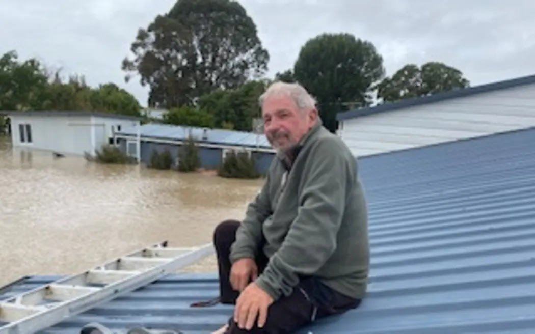 Mike Brown waits to be rescued from his roof in Pakowhai