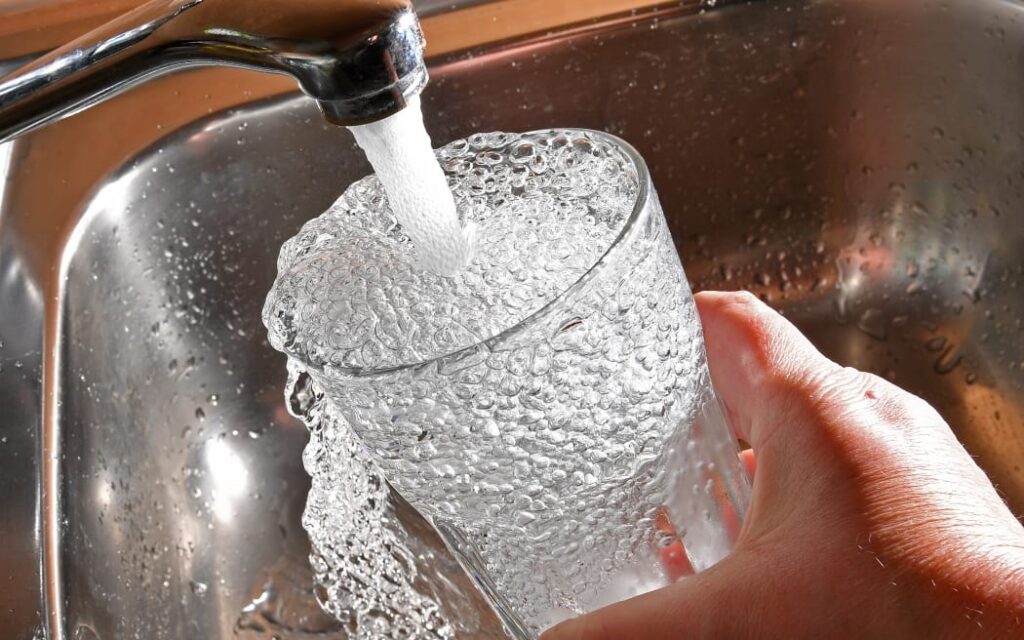 Rototuna: Nước sạch vẫn cần đun sôi, cảnh báo duy trì dù E.coli âm tính 1 Tap water pouring into a glass.