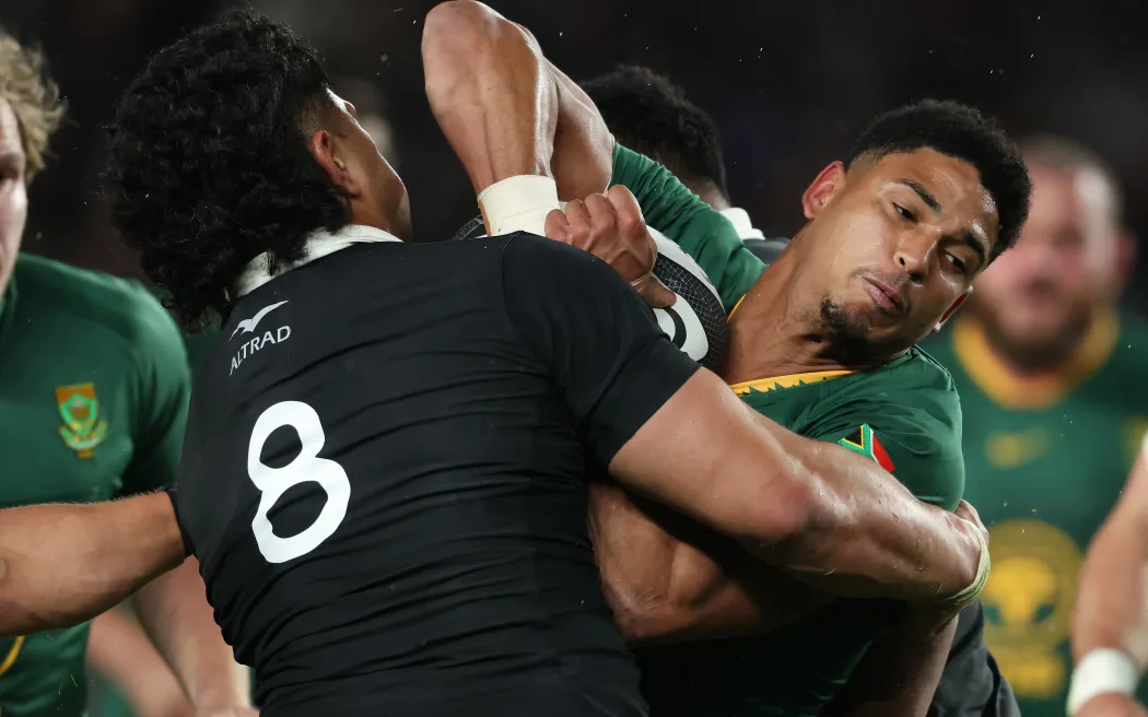 Sacha Feinberg-Mngomezulu of South Africa is tackled by Wallace Sititi, 2025