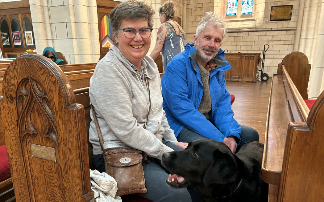 Portrait of a couple with a black dog.