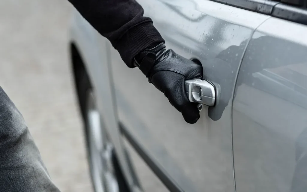 Bảo hiểm có quyền từ chối bồi thường 31.000 USD khi chủ xe bất cẩn 1 Close up on car thief hand pulling the handle of a car. Car thief, car theft concept
