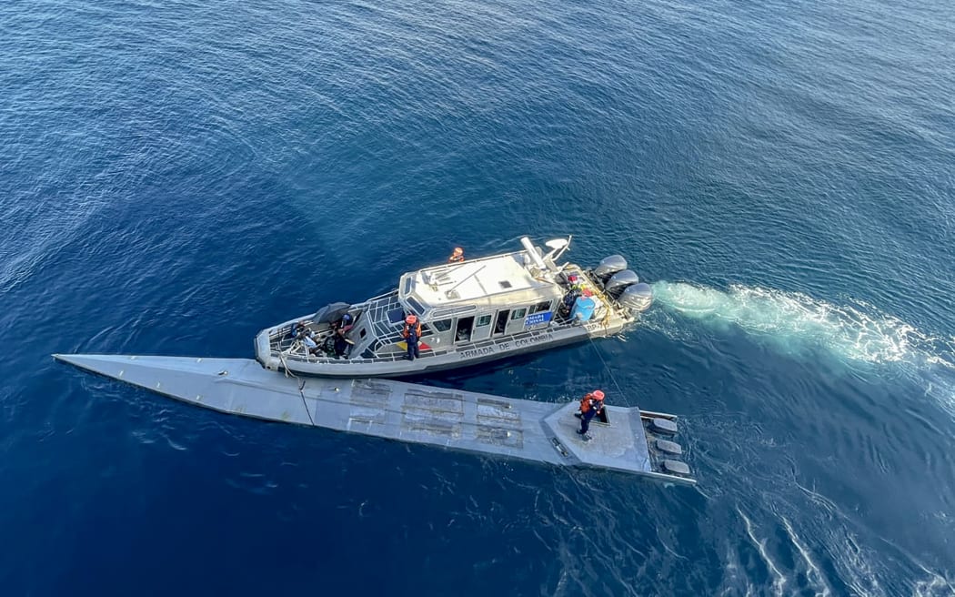 This handout picture released by the Colombian National Navy shows Navy members intercepting and arresting a semi-submersible carrying cocaine hydrochloride in the pacific coast of Colombia on March 13, 2023. The Colombian Navy intercepted a semi-submersible of approximately 15 meters long carrying 2,643 kilograms of cocaine hydrochloride which was destined for distribution in Central America. (Photo by Colombian National Navy / AFP) / RESTRICTED TO EDITORIAL USE - MANDATORY CREDIT "AFP PHOTO / COLOMBIAN NATIONAL NAVY" - NO MARKETING NO ADVERTISING CAMPAIGNS - DISTRIBUTED AS A SERVICE TO CLIENTS