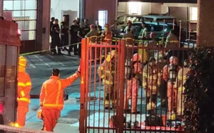 Teams in hazmat gear can be seen outside the Pitt Street fire station following reports of asbestos contamination.