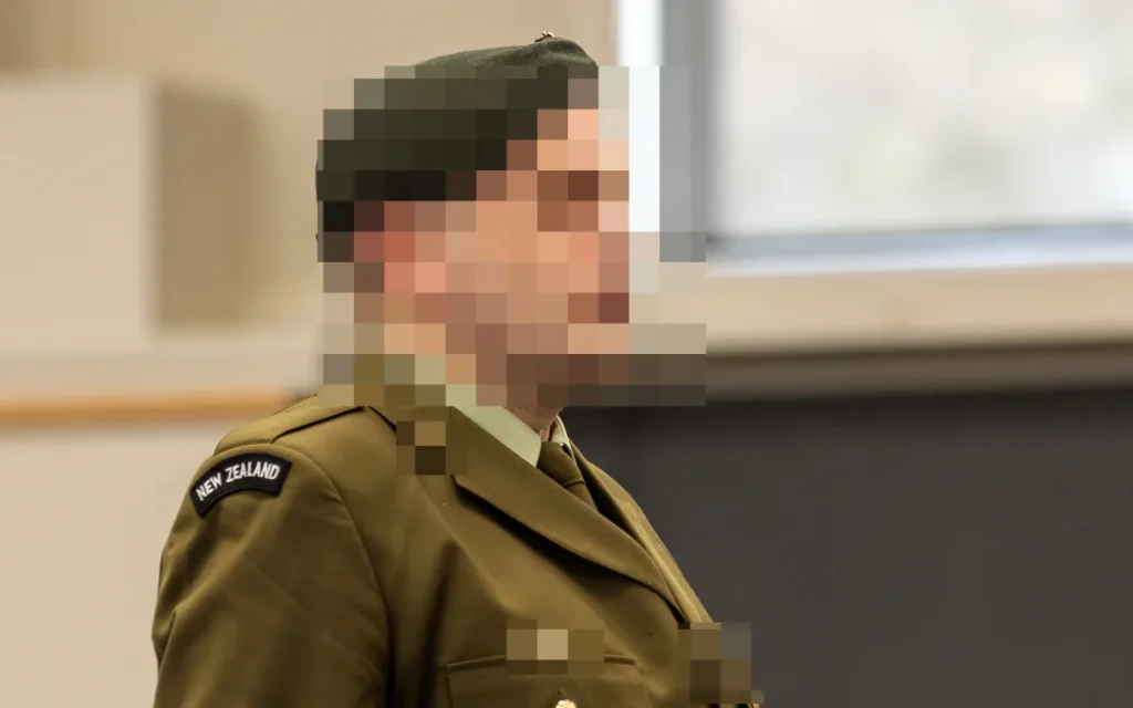 Viện Công tố New Zealand: Quân nhân âm mưu làm gián điệp phải ngồi tù dân sự 1 A New Zealand soldier stands at a makeshift courtroom at the Linton Military Camp located near the city of Palmerston North in New Zealand on August 18, 2025. A military court found a New Zealand soldier guilty of attempted espionage for a foreign power on August 18 -- the first spying conviction in the country's history. The man's name, the country he attempted to spy for and the name of the undercover officer who snared him were all suppressed by the court. The soldier was the first person to be convicted of spying by a New Zealand court and only the second to be tried after a former public servant was acquitted of espionage in 1975. (Photo by Adele Rycroft / POOL / AFP)
