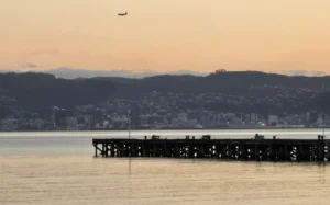 Petone Wharf at sunset, in July 2024, looking across the harbour at Wellington waterfront.