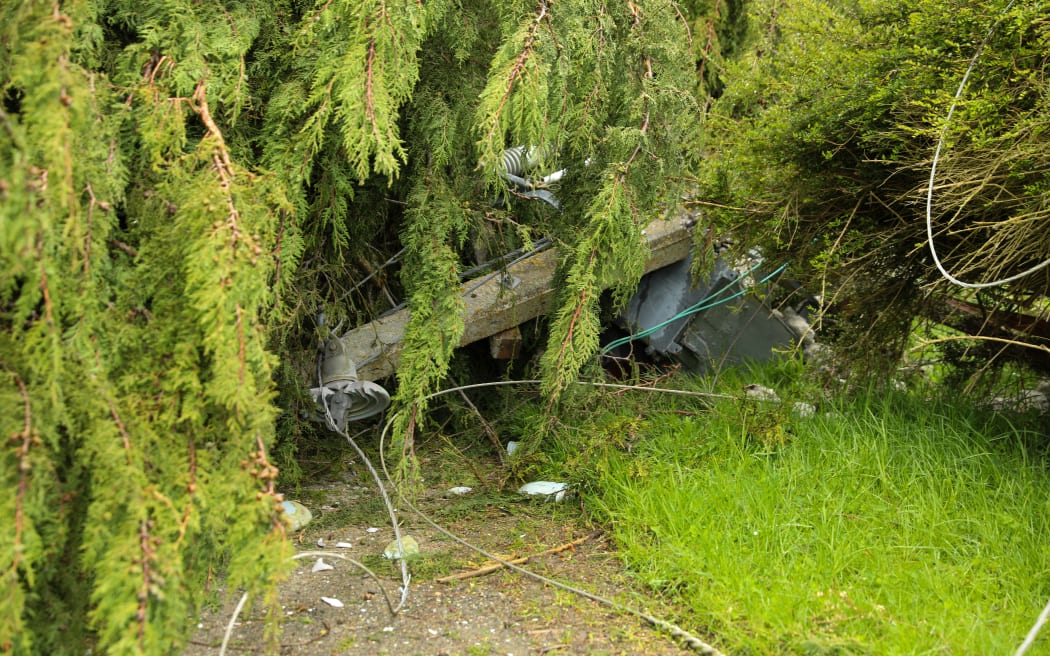 The remains of an electricity transformer visible after being crushed by tree