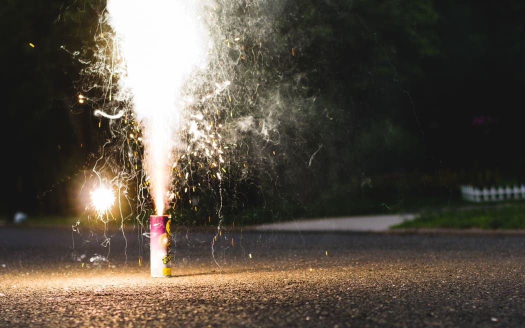 A small firework is set off on a street.