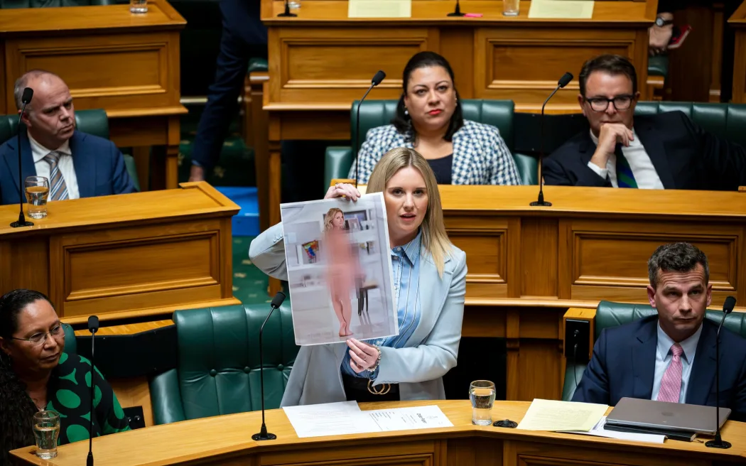 New Zealand: Hình sự hóa deepfake khiêu dâm – Luật mới sẽ hoạt động ra sao? 2 ACT MP Laura McClure holds up a faked nude photo of herself that she created when discussing the Deepfake Digital Harm and Exploitation Bill.