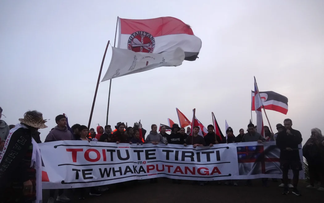 Hīkoi leader Eru Kapa-Kingi addresses the crowd in the early morning mist at Cape Rēinga.