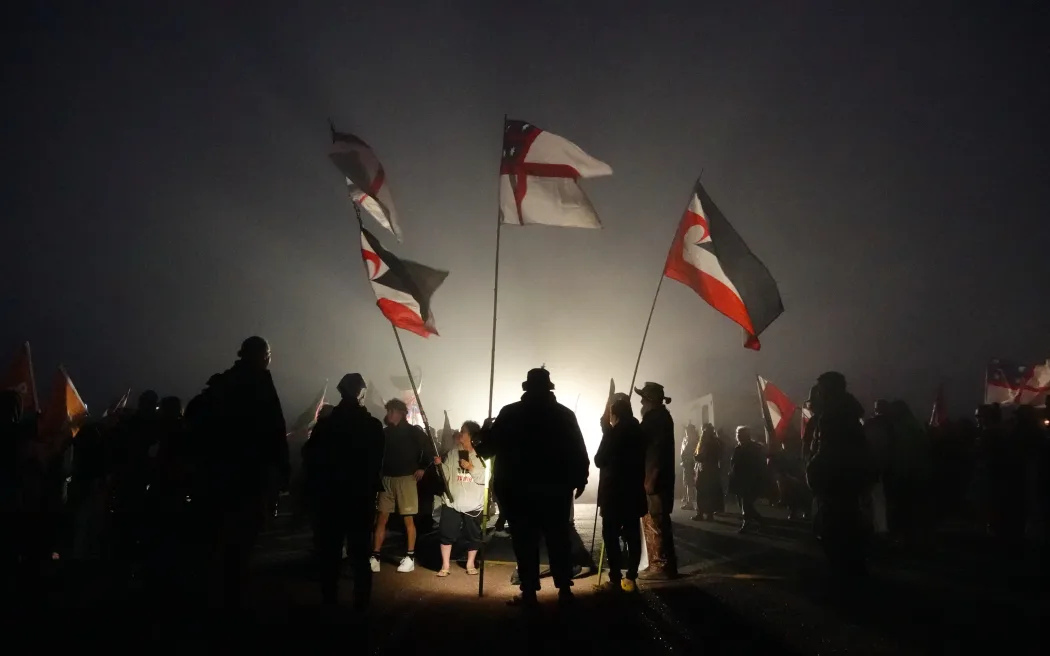 Marchers in the hīkoi gather before dawn at Cape Rēinga.