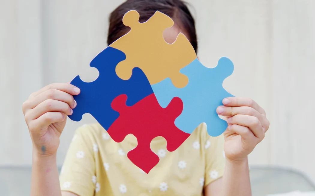 Kid girl hands holding puzzle jigsaw, mental health concept, world autism awareness day
