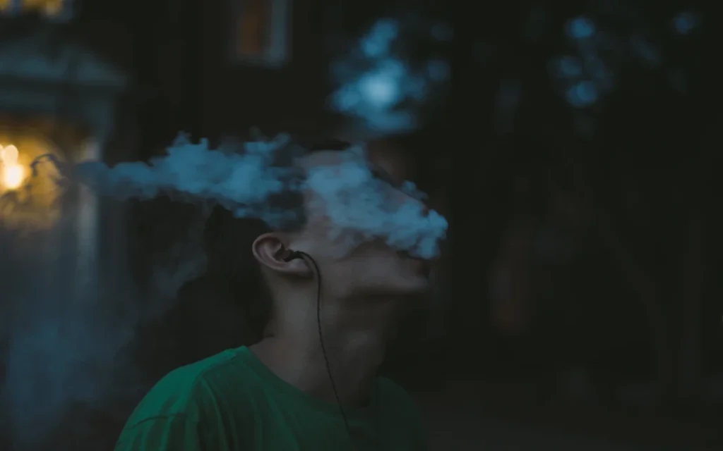 Nghiên cứu bác bỏ: Vape không giảm tác hại mà còn tăng nguy cơ cho giới trẻ Thái Bình Dương 1 Young man with vape, vaping, blowing a vape cloud.