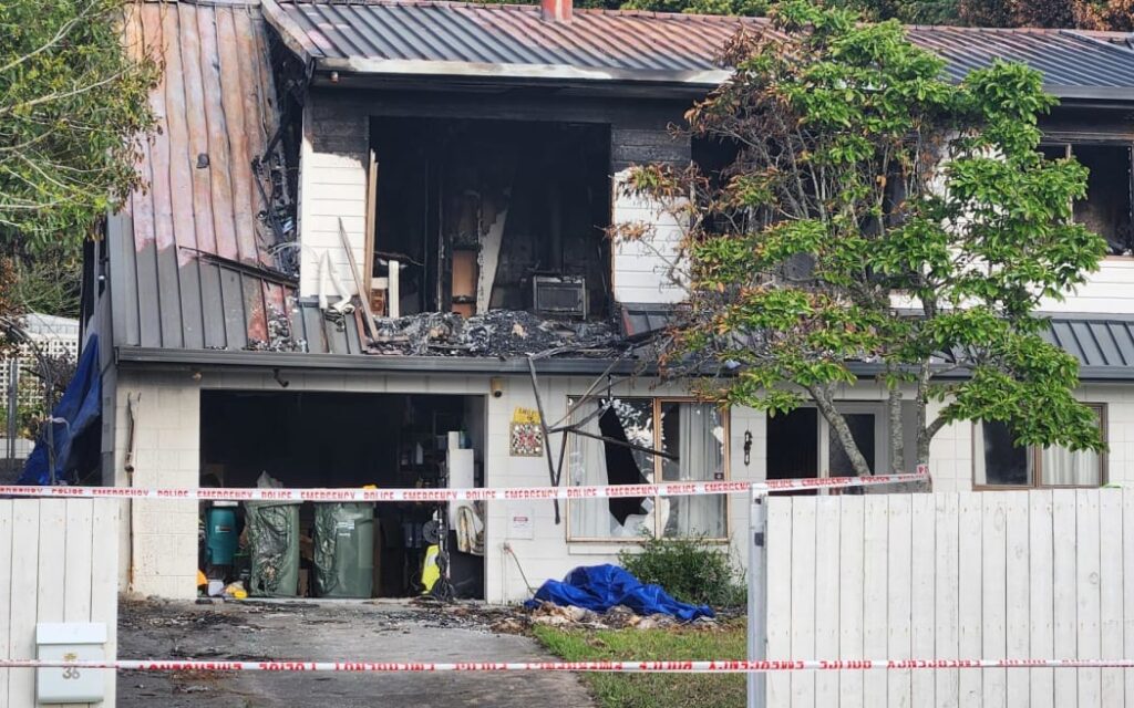 Vụ cháy nhà Bucklands Beach: Nghi phạm không nhận tội giết người kép 1 Police guard at the scene of the Bucklands beach double homicide fire.