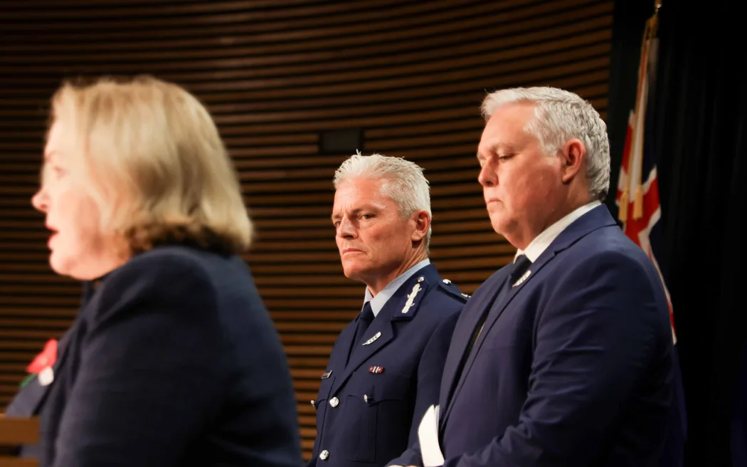 Public Services Minister Judith Collins speaks after a damning report into police conduct, with Police Commissioner Richard Chambers and Police Minister Mark Mitchell in the background.