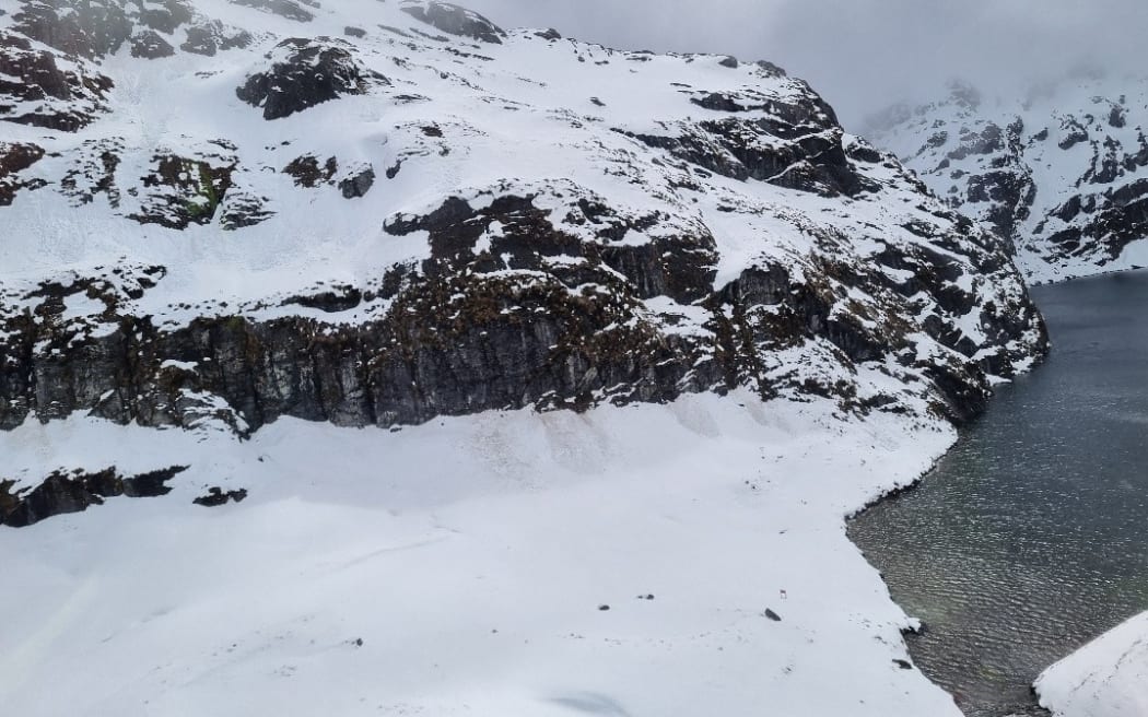 View of Harris Saddle from the Hollyford face. Trampers traverse across this face to/from the Harris Saddle shelter visible.